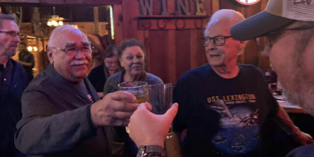 Four people toast on Veterans Day at the Cattlemens in Roseville